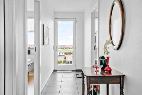 a hallway with a table and a mirror at 70894-Ulfborg-Skolegade-15-Lejl-6 in Thorsminde