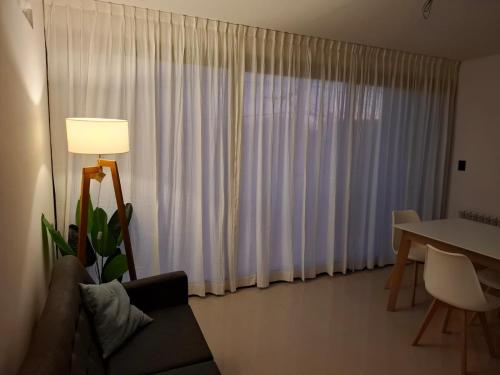 a living room with a table and a white curtain at LaFaldaStayBahia - Confort y Bienestar garantizado in Bahía Blanca