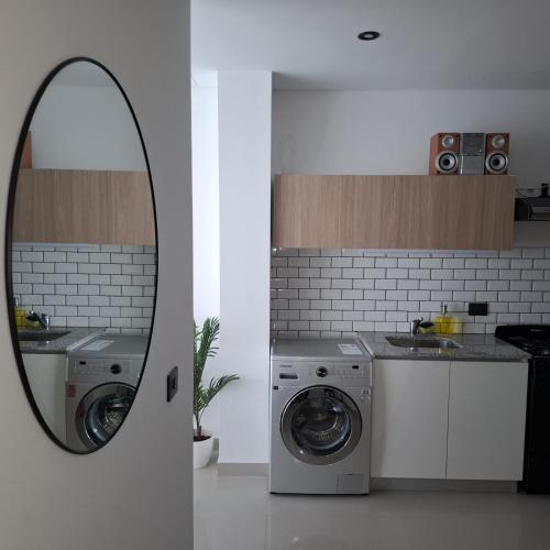 a bathroom with a washing machine and a mirror at LaFaldaStayBahia - Confort y Bienestar garantizado in Bahía Blanca