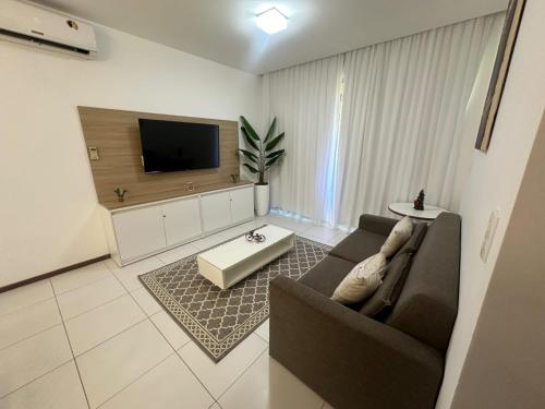 a living room with a couch and a tv at ILOA Apto 02 quartos H in Barra de São Miguel