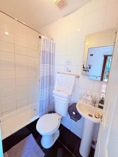 a bathroom with a toilet and a sink at MAKTVB Costanera - Hostal Boutique in Santiago