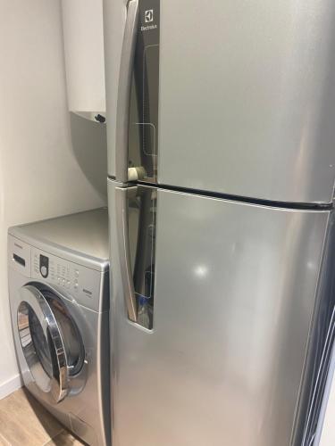a stainless steel refrigerator next to a washing machine at Apartamento Premiun Catedral in La Plata