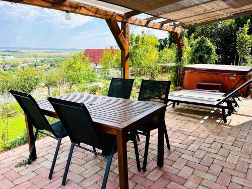 a wooden table and chairs on a patio at Panorama Residence Pákozd in Pákozd