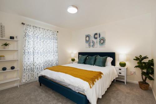 a bedroom with a blue and white bed and a window at Fire Pit Funhouse 2 Master Suites Game Rm in Westminster
