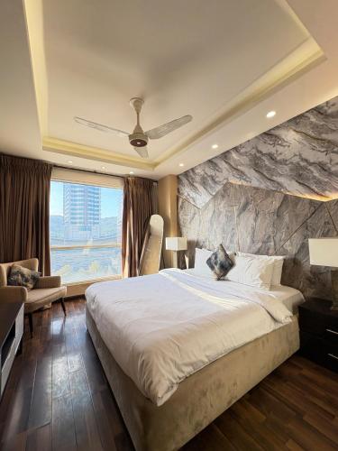 a bedroom with a large bed and a stone wall at Elysium Premium Centaurus View in Islamabad