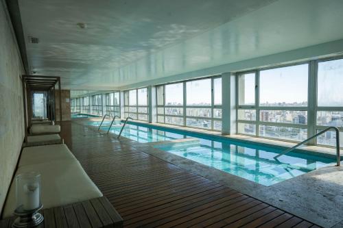 a large swimming pool in a building with windows at Complejo Quartier San Telmo & Spa in Buenos Aires