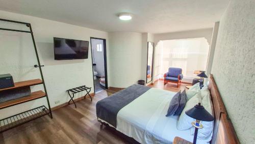 a hotel room with a bed and a chair at Hotel Santiago de Arma in Rionegro