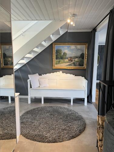 a white bed in a room with a painting on the wall at Traumhaus mit Seegrundstück in Holmsjö