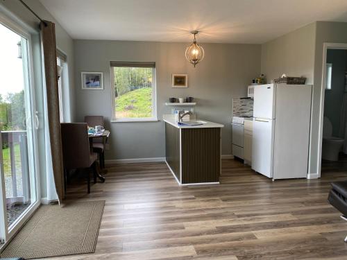 a kitchen with a refrigerator and a table at Lupine Cottage - Alaska at your doorstep! in Palmer