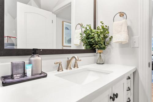 Un baño blanco con lavabo y espejo. en Elon Loft, en Elon