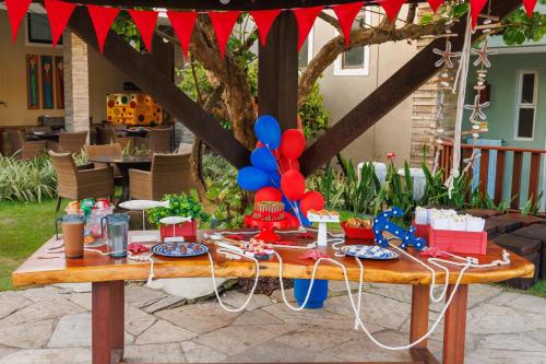 a picnic table with red and blue balloons on it at Hotel Solar Porto de Galinhas in Porto De Galinhas