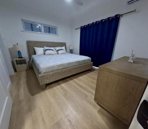 a bedroom with a bed and a blue curtain at Townhouse Villa 5 The Village at Hoopers Bay in New Providence Island