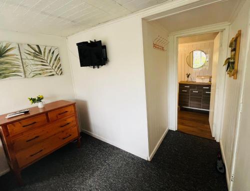 a room with a dresser and a television on a wall at Hostel Isla del Rey in Valdivia