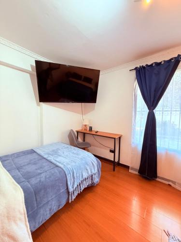 a bedroom with a bed and a desk and a television at MAKTVB Costanera - Hostal Boutique in Santiago