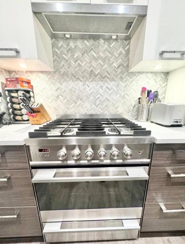 a kitchen with a stove top oven in a kitchen at Kitsilano Retreat at Private 3 Bed with Parking and BBQ in Vancouver