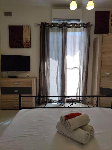 a bedroom with a bed with two towels on it at Corner view 2 in Iż-Żlielaq