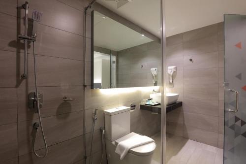 a bathroom with a shower and a toilet and a sink at Amerin Hotel Johor Bahru in Johor Bahru