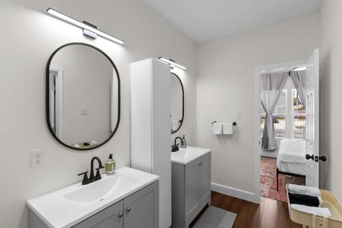 a white bathroom with a sink and a mirror at Gated 5BR Duplex Med Center Downtown NRG in Houston