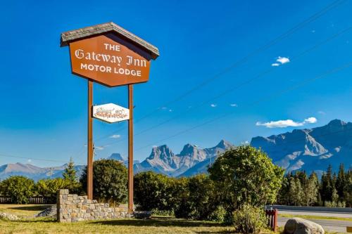 a sign for the gibraltar inn morro lodge with mountains in the background at Gateway Suites Explore the Rocky Mountains in Canmore