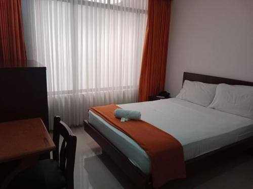 a bedroom with a bed with a pillow on it at Hotel Lancers Casimena Yopal in Yopal