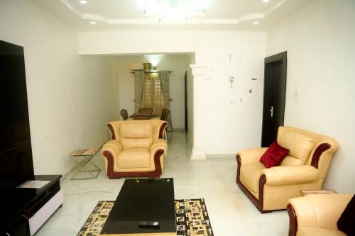 a living room with two chairs and a table at Cremyark Homes in Benin City