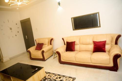 a living room with a couch and two chairs at Cremyark Homes in Benin City