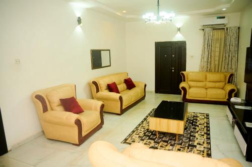 a living room with two chairs and a coffee table at Cremyark Homes in Benin City