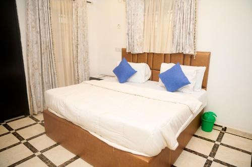 a bedroom with a bed with blue pillows at Cremyark Homes in Benin City