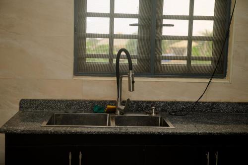 a kitchen sink with a faucet next to a window at Cremyark Homes in Benin City