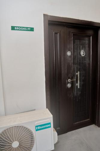 a brown door with a fan next to a microwave at Cremyark Homes in Benin City
