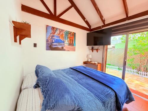a bedroom with a blue bed and a window at MAKTVB Costanera - Hostal Boutique in Santiago