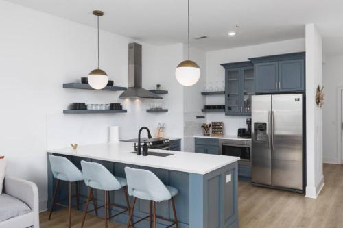 a kitchen with blue cabinets and a kitchen island with bar stools at Sleeps 16 Two Condos Side by Side Only 3 miles Broadway in Oklahoma City