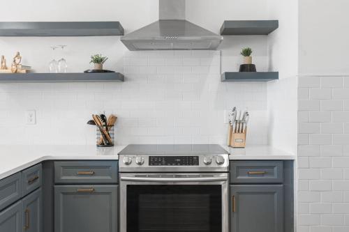 a kitchen with gray cabinets and a stove at Sleeps 16 Two Condos Side by Side Only 3 miles Broadway in Oklahoma City