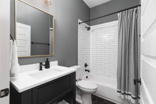 a white bathroom with a sink and a toilet at Sleeps 16 Two Condos Side by Side Only 3 miles Broadway in Oklahoma City