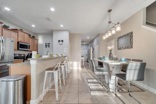 a kitchen with a bar and some stools in it at 5BR Paradise Palms Townhome POOL by Disney in Kissimmee