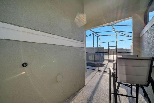 a room with a balcony with a table and chairs at 5BR Paradise Palms Townhome POOL by Disney in Kissimmee