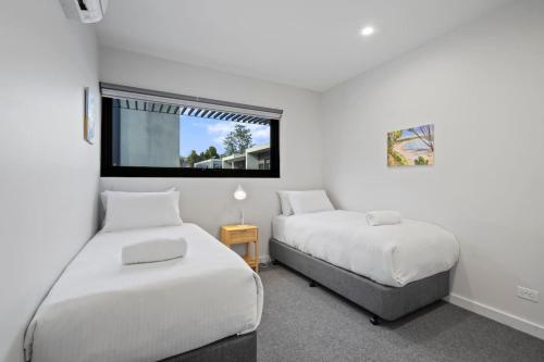 a bedroom with two beds and a window at Luxury 3 storey residence in Melbourne