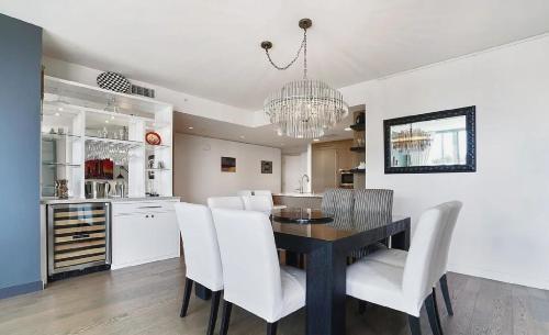 ロサンゼルスにあるSuperb Two Bedroom Condo in Santa Monicaのキッチン、ダイニングルーム(テーブル、白い椅子付)