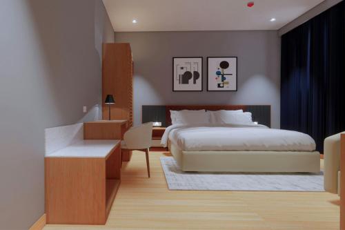 a bedroom with a bed and a table and a desk at Protea Hotel by Marriott Kinshasa in Kinshasa