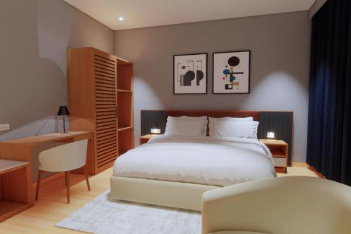 a bedroom with a bed and a desk and a chair at Protea Hotel by Marriott Kinshasa in Kinshasa