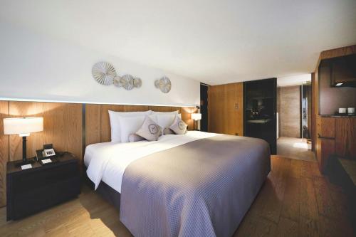 a bedroom with a large white bed and wooden walls at Madison Taipei, a Tribute Portfolio Hotel in Taipei