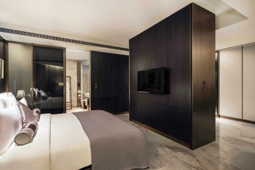 a bedroom with a bed and a tv on a wall at Madison Taipei, a Tribute Portfolio Hotel in Taipei