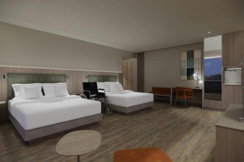 a hotel room with two beds and a desk at Courtyard by Marriott Quito Airport in Quito