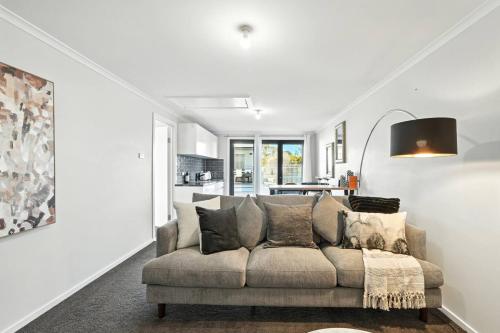 a living room with a couch and a kitchen at Beachside Studio Retreat in Seven Mile Beach