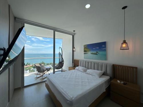 ein Schlafzimmer mit Bett und Blick auf das Meer in der Unterkunft exclusivo apto 112 sierra beach by vacationvip in Playa Bello Horizonte