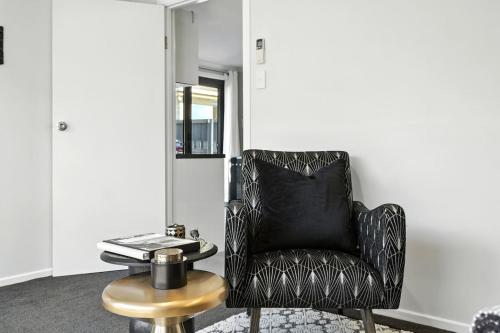 a black chair sitting in a room with a table at Beachside Studio Retreat in Seven Mile Beach