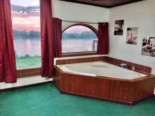 eine große Badewanne in einem Zimmer mit einem großen Fenster in der Unterkunft Riverfront 2 bdrm Jacuzzi Cabin with Sunset Balcony in Saint Joseph