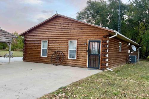 a log cabin with a large door in a yard at Riverfront Studio Cabin with Best View and Huge Yard in Saint Joseph