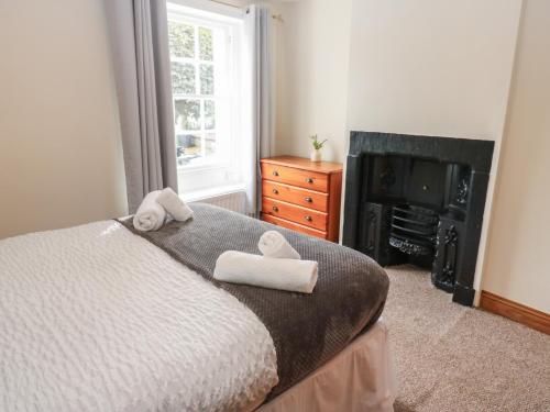 a bedroom with a bed with towels on it at Kirkgate Cottage in Cockermouth