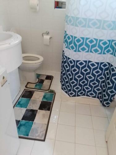 a bathroom with a toilet and a shower curtain at LILIA in Poros